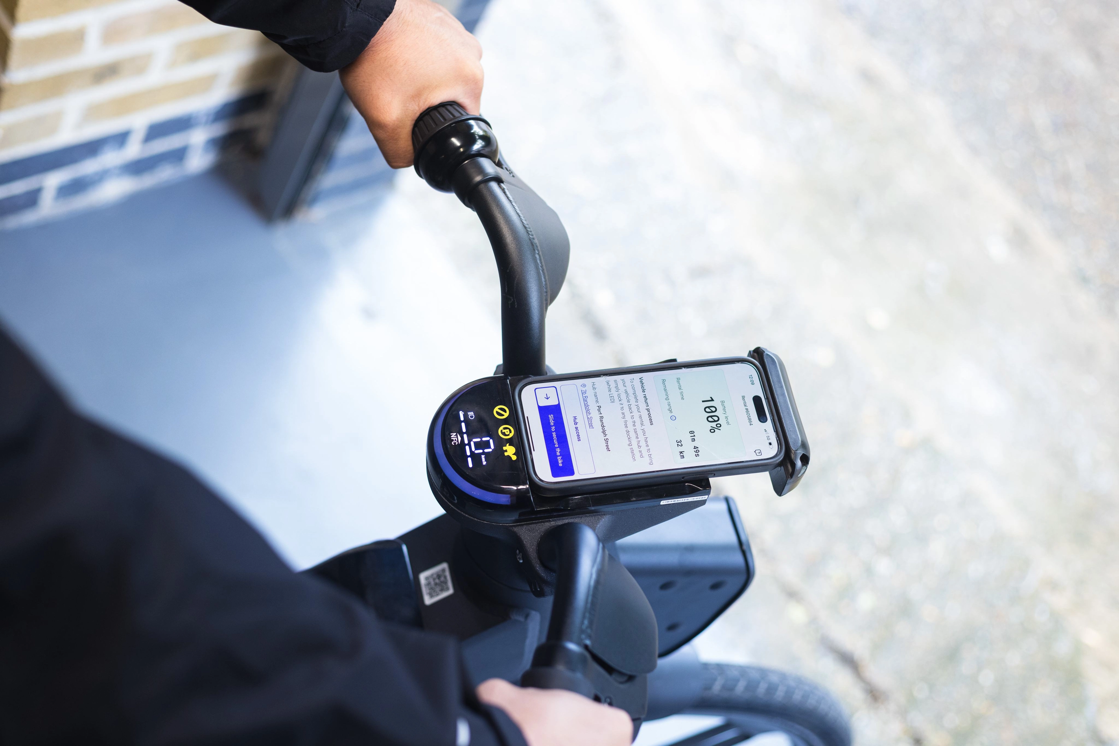 A delivery driver dressed safely is renting an e-bike using a connected platform
